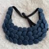 Collier plastron en boutons jean bleu sur fond beige