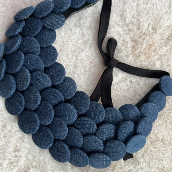 Collier plastron en boutons jean bleu sur fond beige